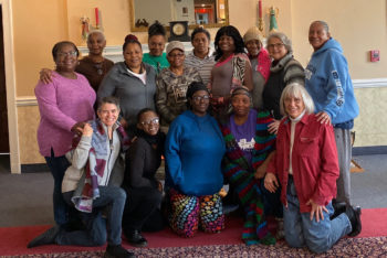 Retreatants and team members gather together for a group photo indoors.